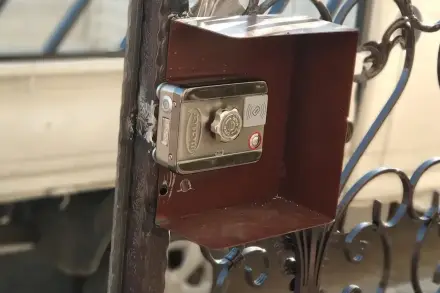 Ferforje bahçe kapısına monte edilmiş Merter akıllı kilit, yağmur koruyucu siperlikli